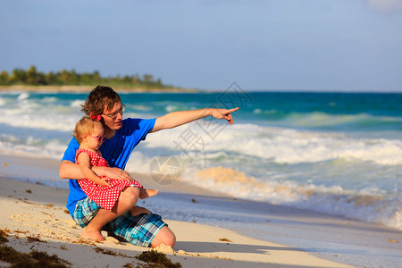 父亲和小女儿在夏日海滩上玩得开心图片
