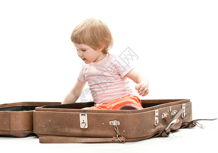 可爱的小孩在一个大手提箱里摄影棚拍图片