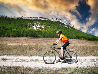 少女骑士物语青春运动少女在日落时乘自行车在山背景