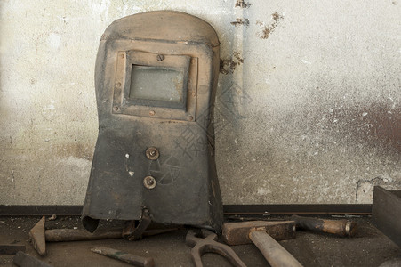 旧的焊工面具和家用车库中背景图片