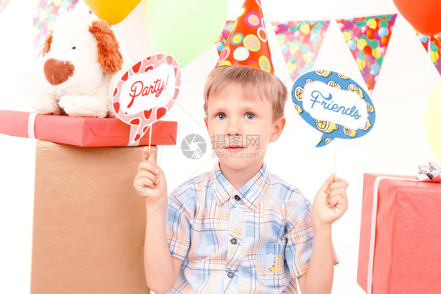 生日标志坐在一堆礼物背景上的小好男孩拿着带有生日相图片