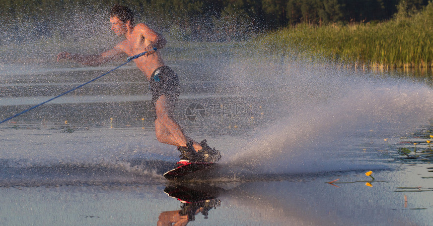 Wakeboarder运动员用燃烧的喷雾在水中滑行乌克兰图片