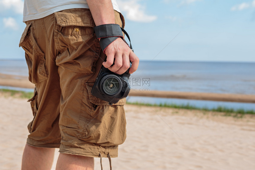 男人穿著衬衣和服站在海边的沙滩上图片