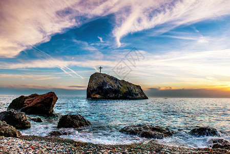 蓝海沙滩岩石和戏剧天空图片
