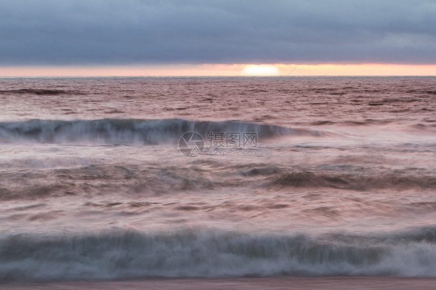 太阳在地平线下落日浓密的雾库典型的加利福尼亚海岸和波图片