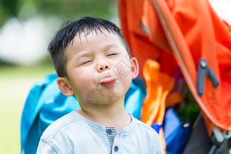 可爱的亚洲小男孩露出舌头来做图片