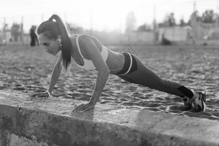 健身女人做推ups户外训练锻炼的夏夜概念的健康的生活方式图片