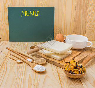 面板空白的木桌上有不同的甜面包成份谷物和图片
