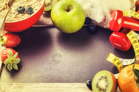 配有哑铃和新鲜水果的适合框架带有复制空间的健康背景图片