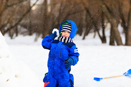 小男孩在冬季积雪中挖掘和玩耍孩子图片