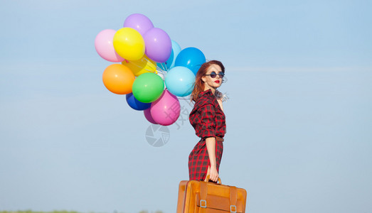穿着格子裙的漂亮女孩满身多色气球和图片