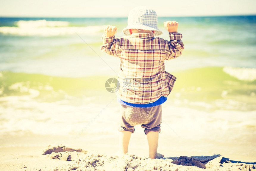 小孩在夏日天气好时在海边玩耍照片带有古图片