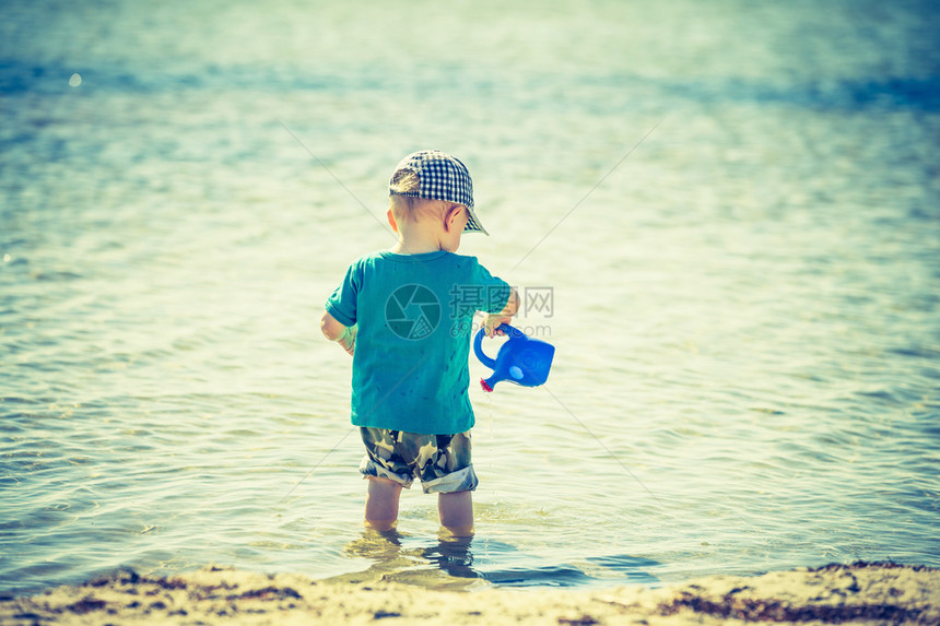 小孩在夏日天气好时在海边玩耍照片带有古图片