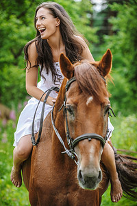 美丽的年轻女子公园骑马图片