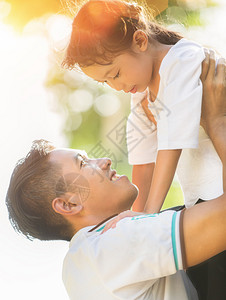 小女孩用自然和阳光拥抱爸的肖图片