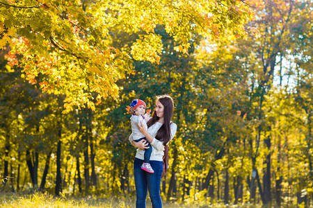 家庭幸福母亲和儿女小儿在秋天散步图片