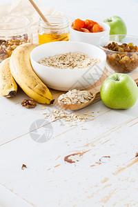 白碗香蕉蜂蜜白木背景中的秋季燕麦片图片