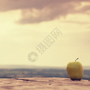 木桌书上的黄绿色苹果背景图片