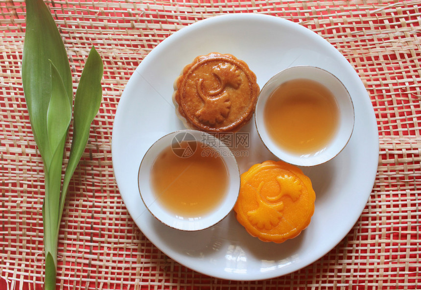 绿叶菜上的月饼和茶节日食品图片