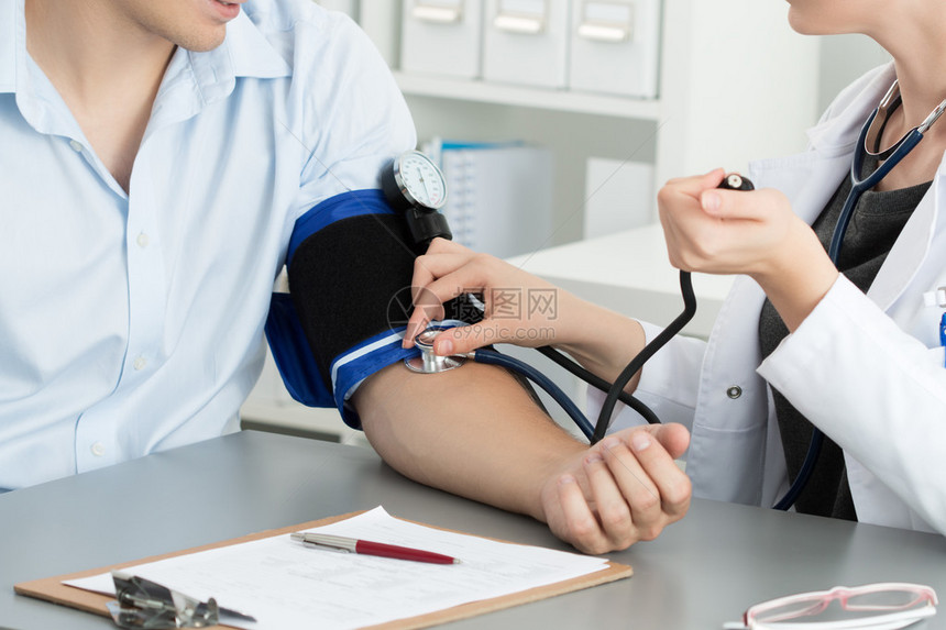 测量病人血压的女医学生图片
