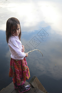 一个四岁女孩在湖中钓鱼的肖像反射图片