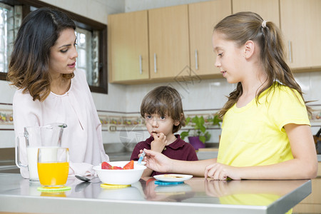 可爱的母亲和她的孩子在厨房吃早餐图片
