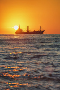 在美丽的日出海港附近航行的货船图片