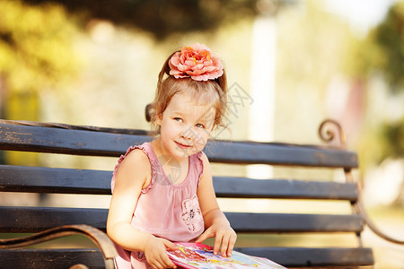 一个聪明小女孩的肖像在公园长椅上看儿童图片