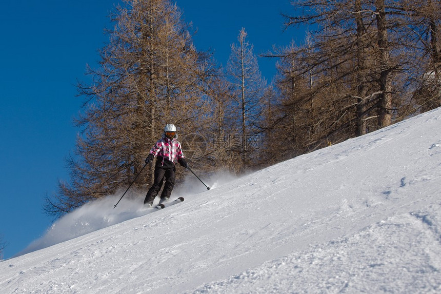 女滑雪者从斜坡上下来图片