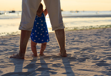 父亲和小女儿在日落海图片