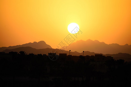 温暖的夕阳与埃及的山脉和房屋图片
