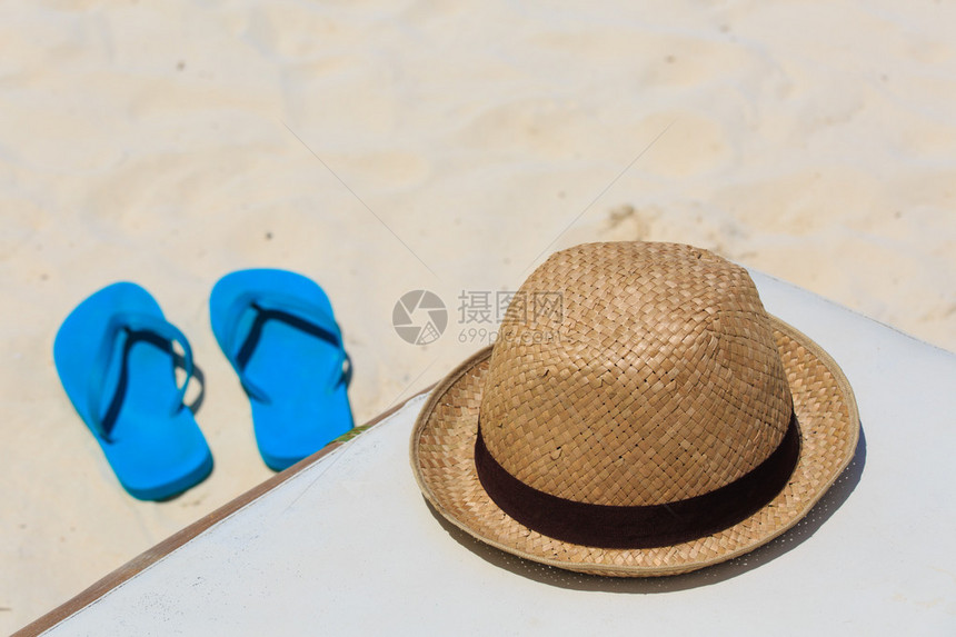 沙滩上的草帽和人字拖度假概念图片