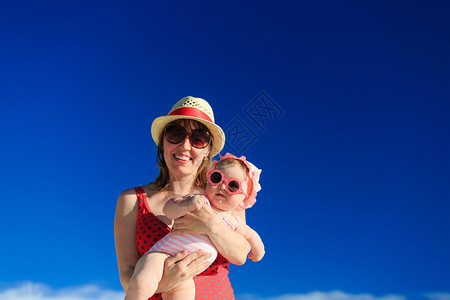 母亲和婴儿在沙滩度假时再次出图片