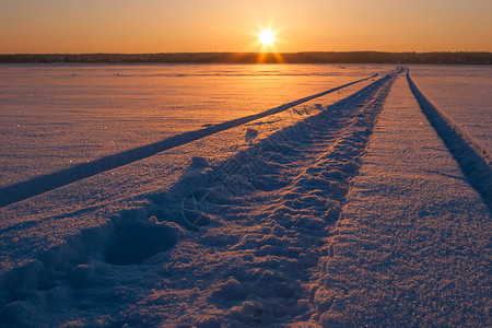 日落时雪面上车辆的痕迹图片