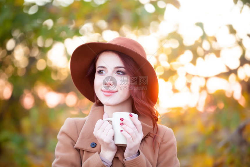 秋季在户外喝杯茶或咖啡的女人图片