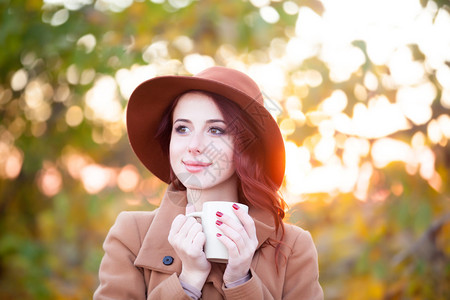 秋季在户外喝杯茶或咖啡的女人图片