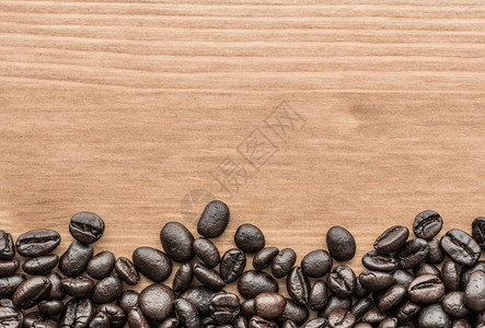 木板表面棕色咖啡豆的紧图片