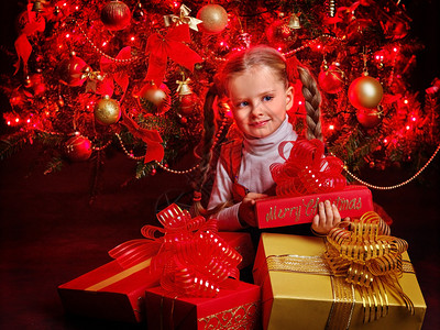 儿童持有团体礼物盒坐在圣诞树图片