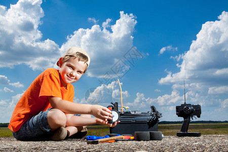 小男孩修理无线电遥控车户外近场图片