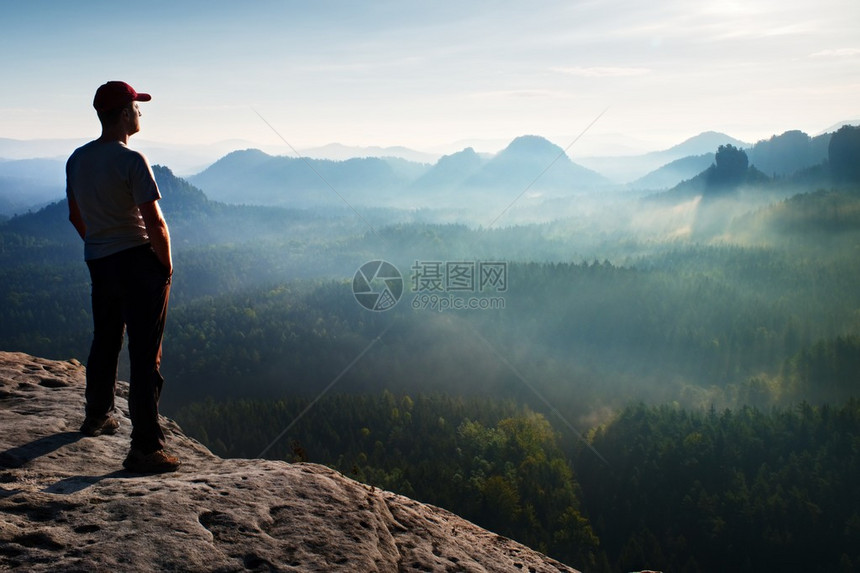 希克站立在岩石帝国公园的沙石岩峰上看着迷雾图片