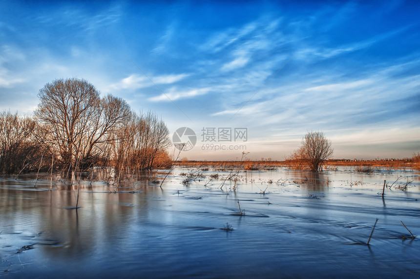 春天的河水泛滥成一片蓝天下的田野图片