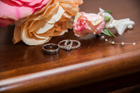 美丽的结婚戒指在明亮红花背景的红图片