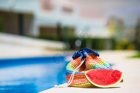 泳池附近暑假的多彩条纹袋太阳图片