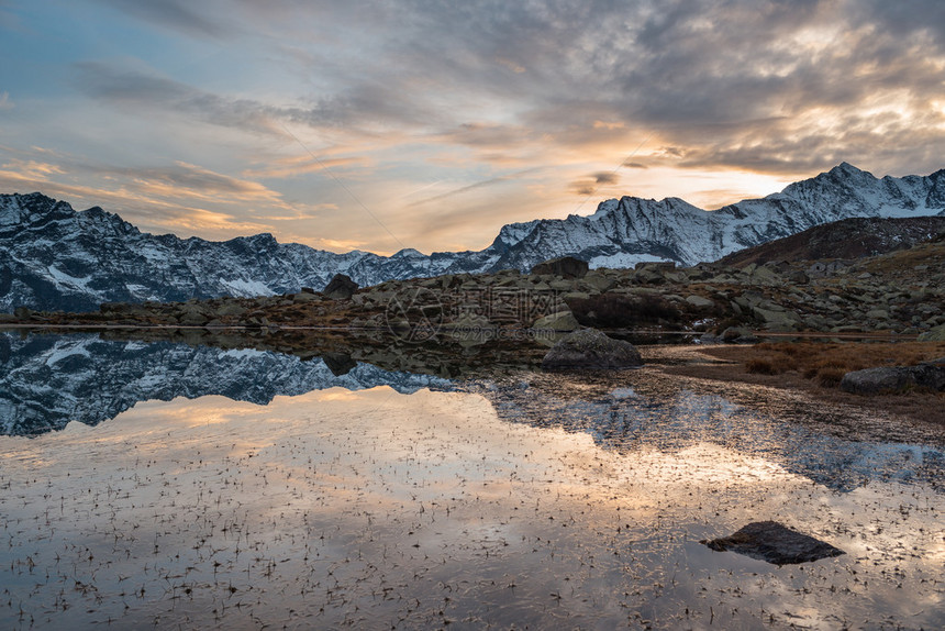 曾经被冰川覆盖的田园诗般的土地上的高海拔高山湖泊白雪皑的山脉和风景秀丽的五颜六色的天空在日落时的倒影广角拍摄于海拔2200m的意图片