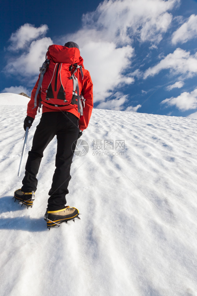 一名男登山者在冰河上爬山图片