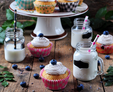 蓝莓自制纸杯蛋糕和一罐牛奶木图片