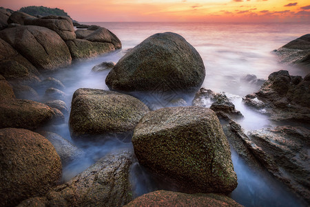 泰国普吉岛的日落与岩石和海滩图片