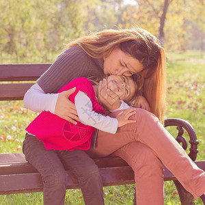 快乐的年轻母亲和小女孩在公园里玩得开心家庭生图片