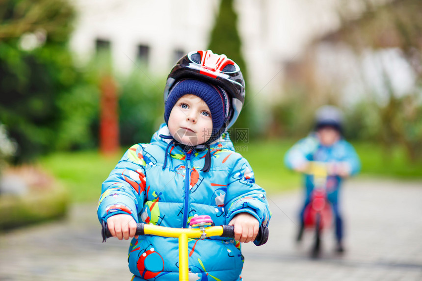 2岁的小男孩在市公园骑着第一辆自行车骑马图片