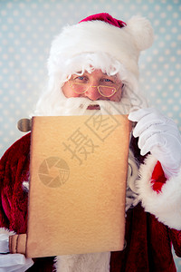 圣誕老人手握纸卷空白圣诞节假日概念图片